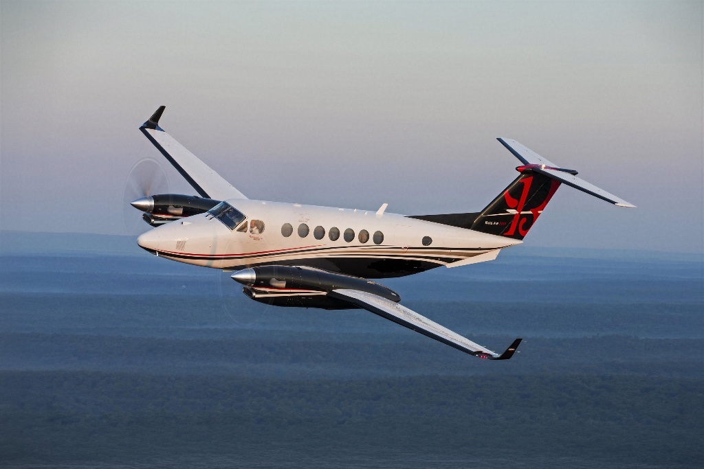 King Air 200 in flight over the ocean at dusk